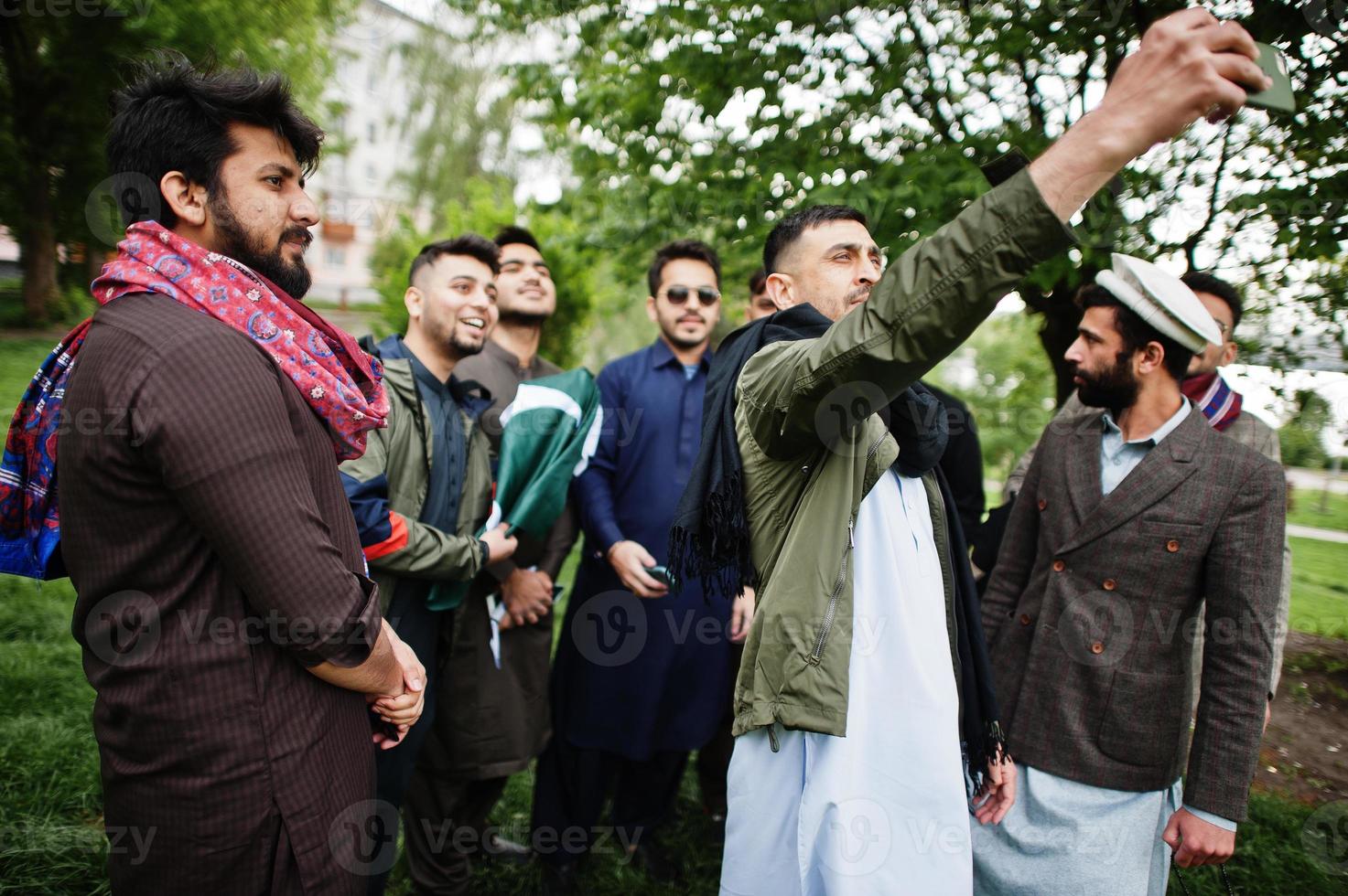 Group of pakistani man wearing traditional clothes salwar kameez or kurta making selfie on mobile phone. photo