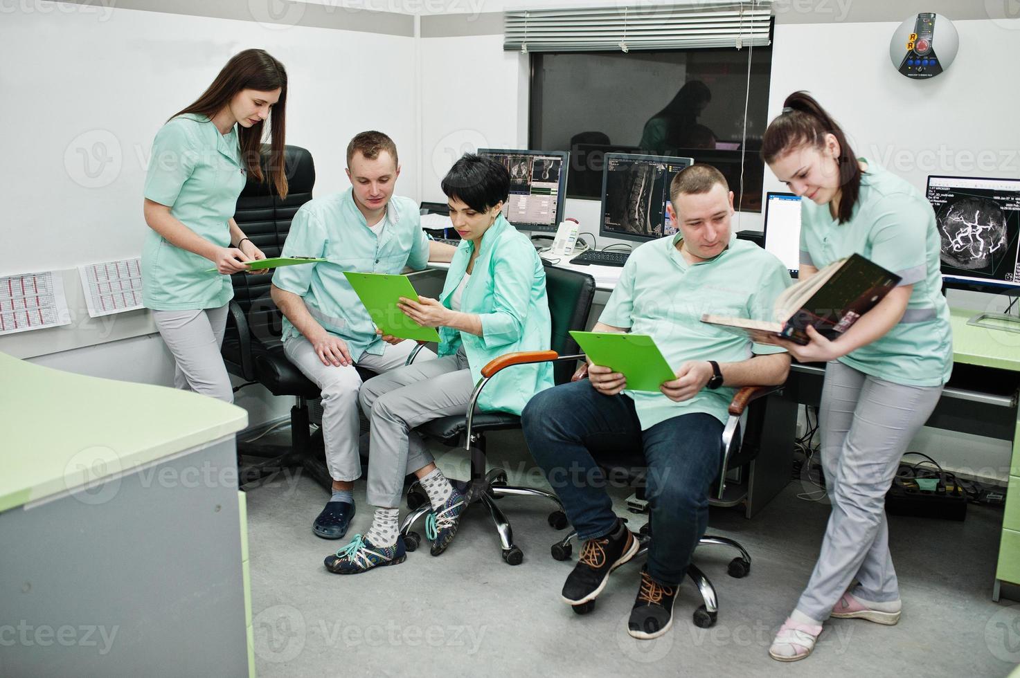 Medical theme.Observation room with a computer tomograph. The group of doctors meeting in the mri office at diagnostic center in hospital. photo