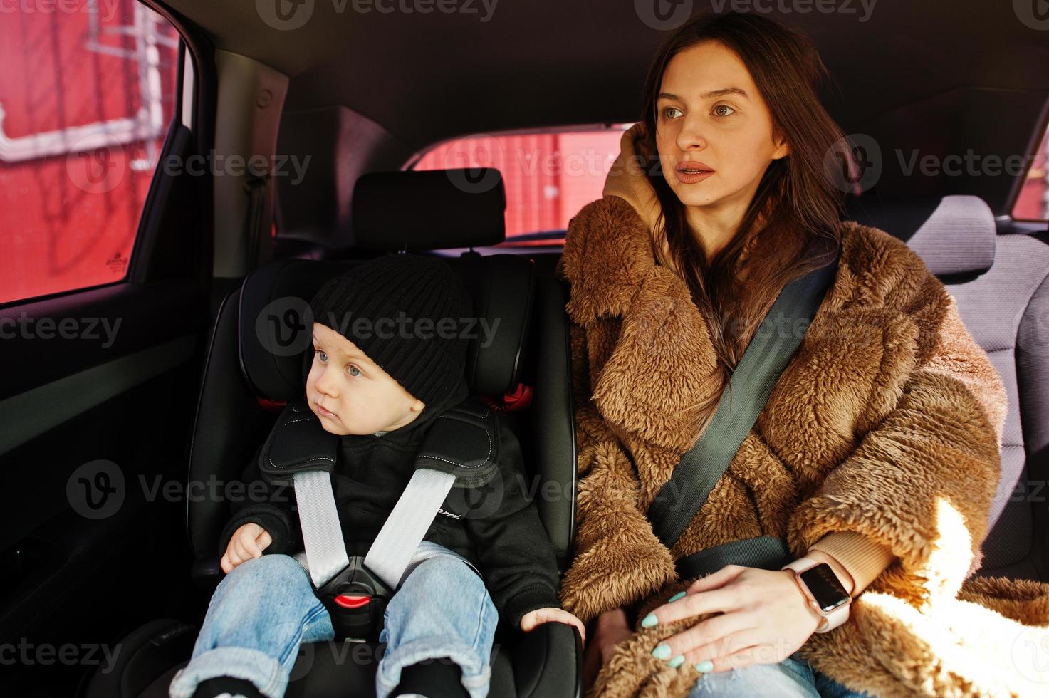 Young mother and child in car. Baby seat on chair. Safety driving concept. photo