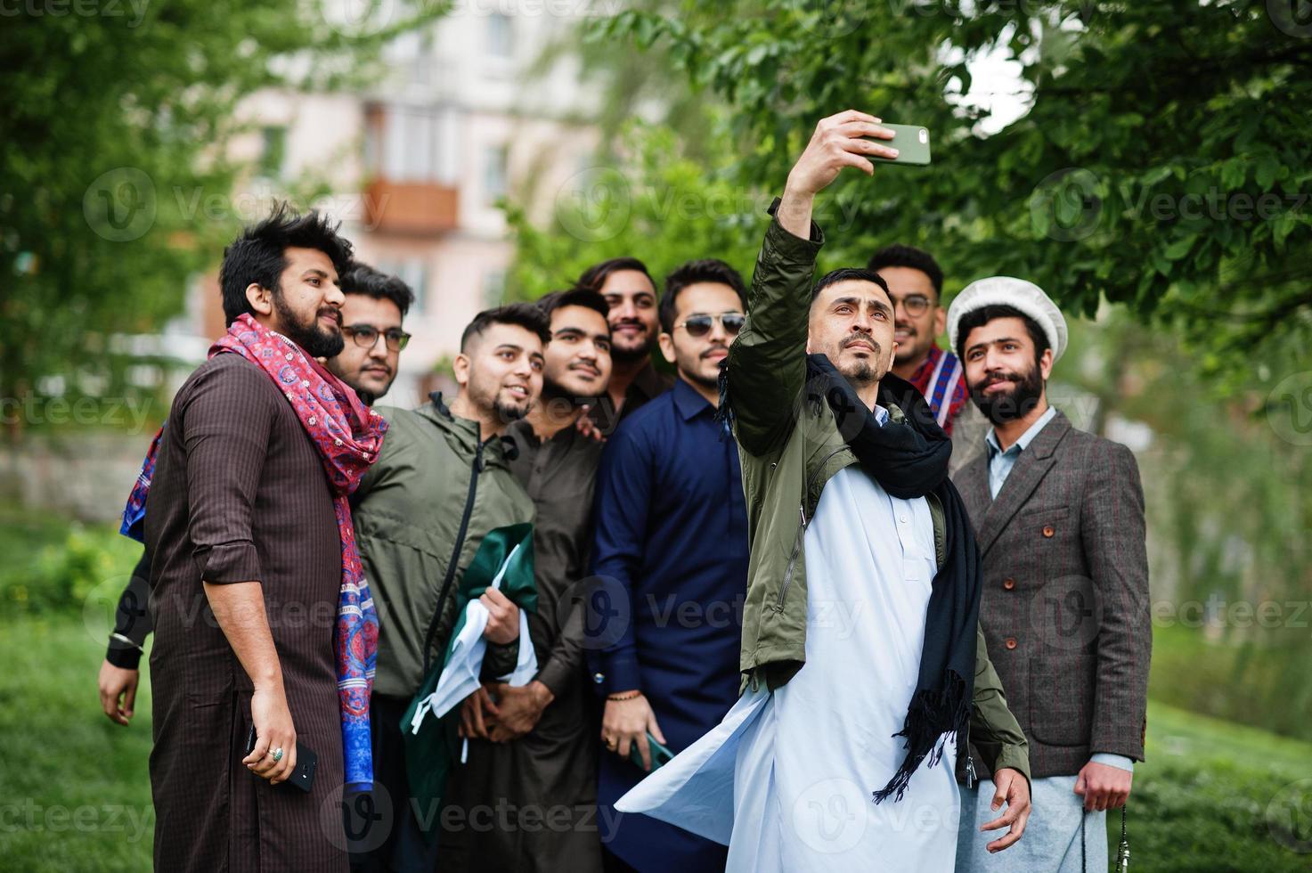 Group of pakistani man wearing traditional clothes salwar kameez or kurta making selfie on mobile phone. photo
