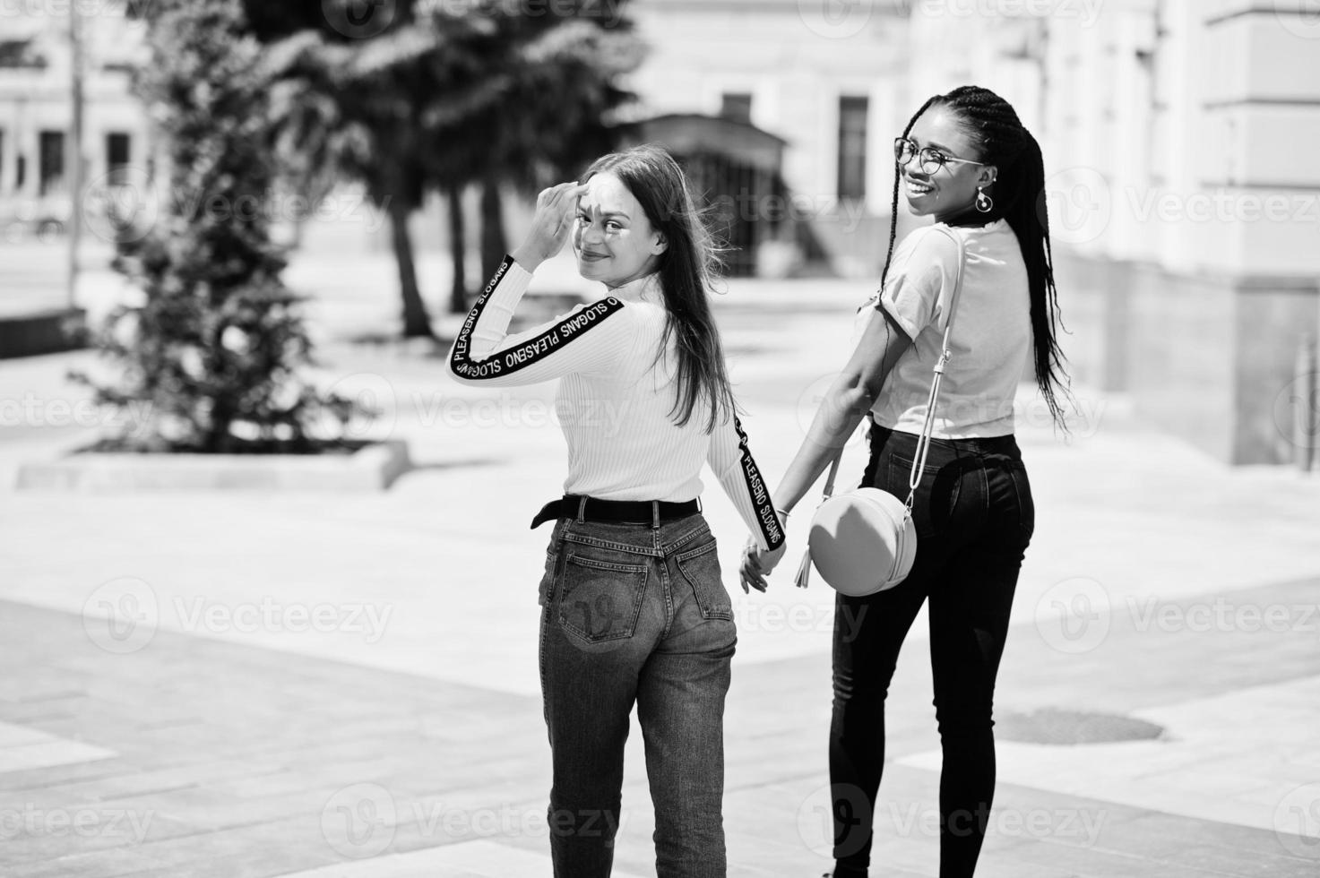 White caucasian girl and black African American together holding hands. World unity, racial love, understanding in tolerance and races diversity cooperation. photo