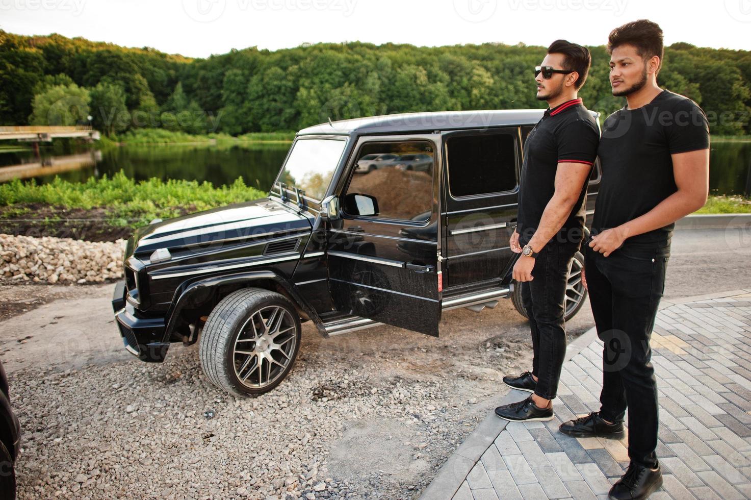 Two asian brothers man wear on all black posed near suv car. photo