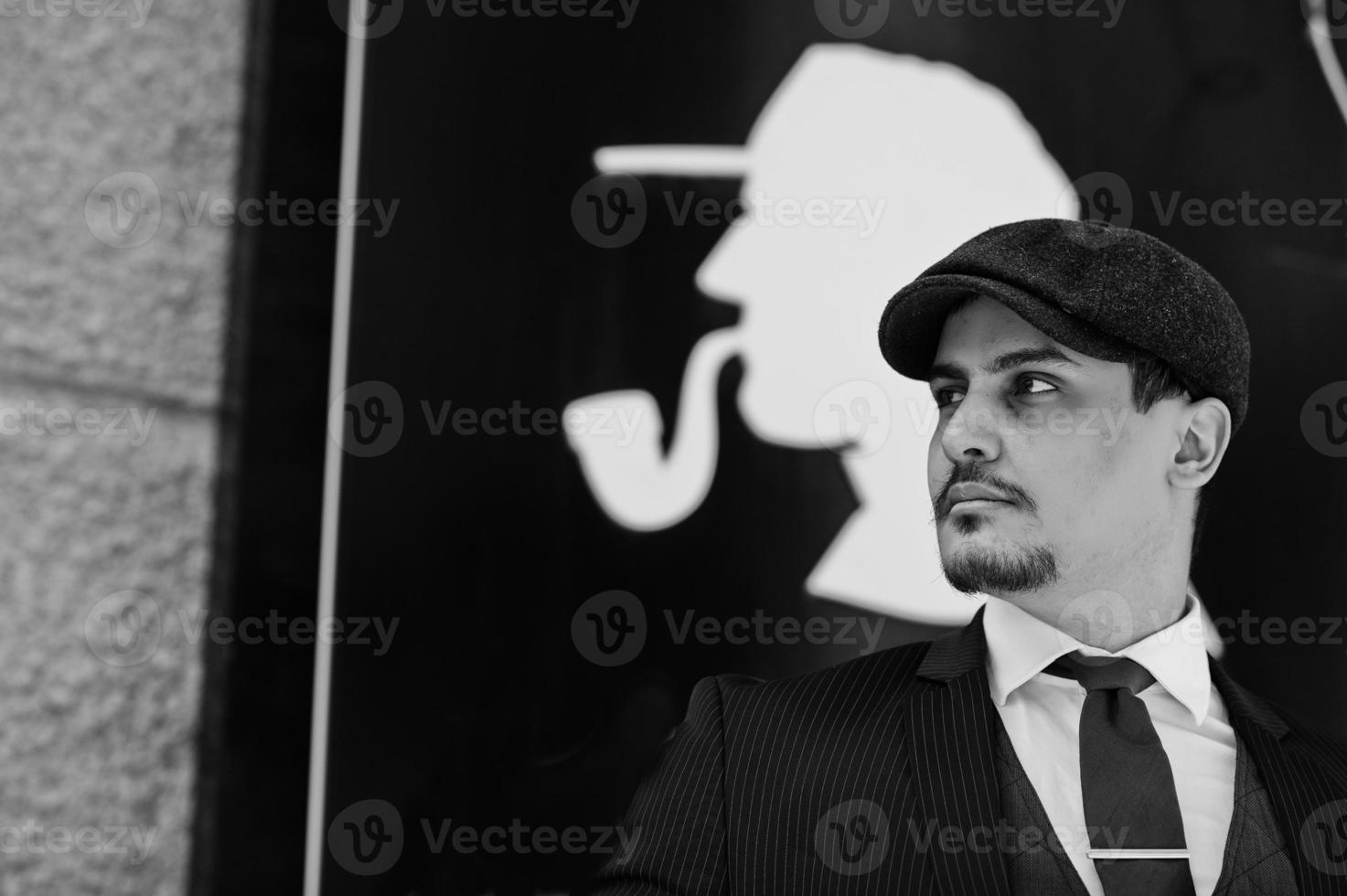 retrato de un hombre de negocios árabe inglés retro de los años 20 con traje oscuro, corbata y gorra plana. foto