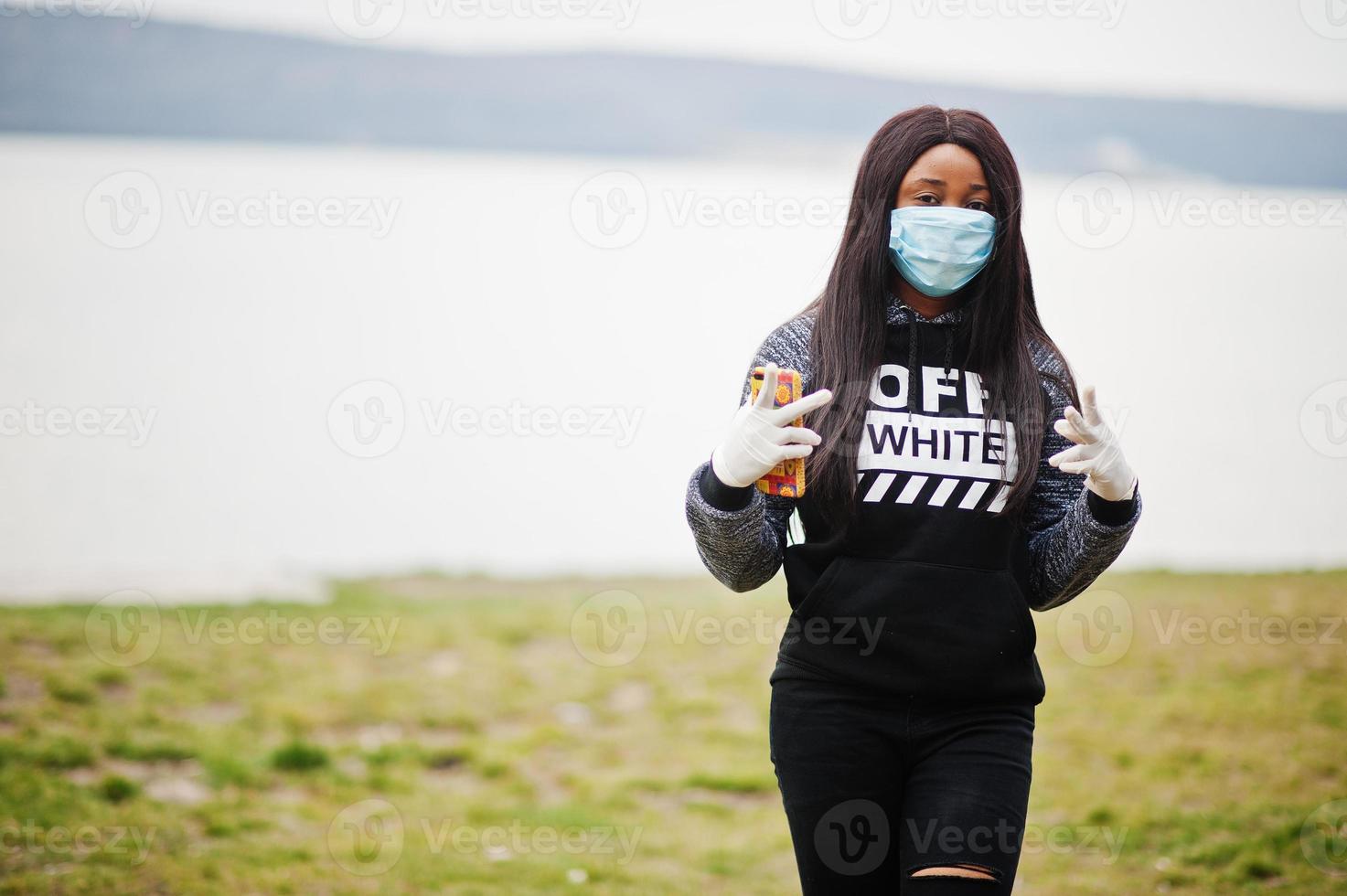 niña africana en el parque con máscaras médicas para protegerse de infecciones y enfermedades cuarentena del virus del coronavirus. foto