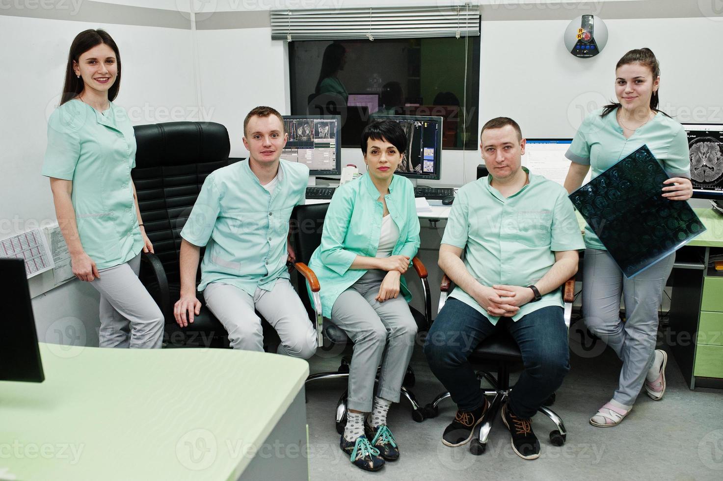 tema médico.sala de observación con un tomógrafo computarizado. el grupo de médicos reunidos en la oficina de resonancia magnética en el centro de diagnóstico del hospital. mantenga la imagen radiográfica de rayos x. foto