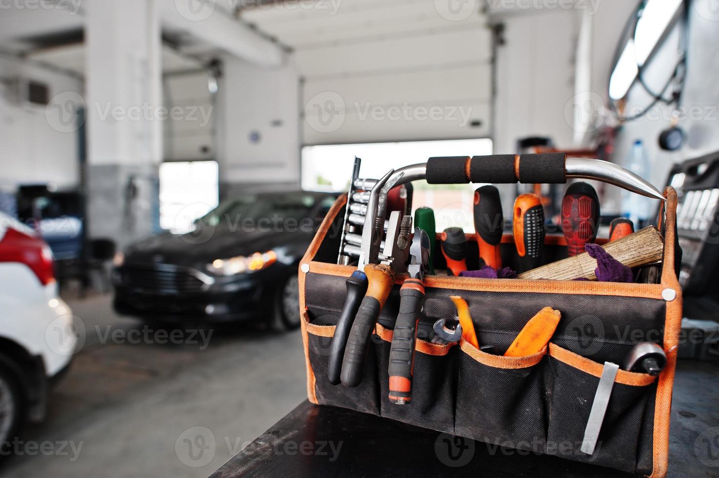 Car repair and maintenance theme. Mechanic in uniform working in auto service. photo