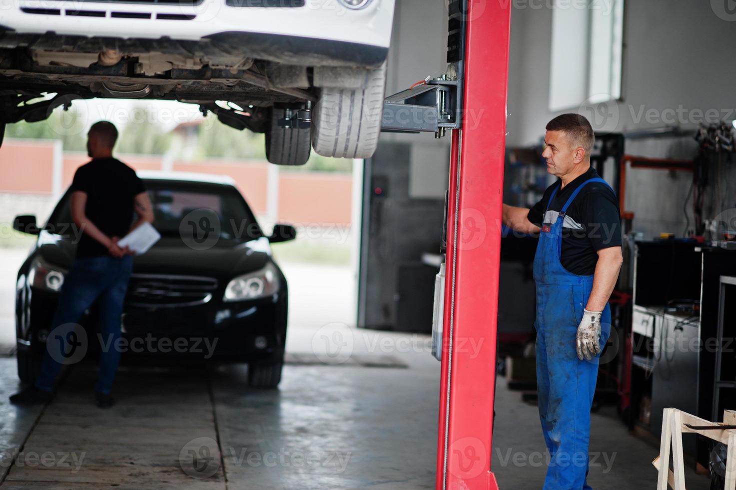 tema de reparación y mantenimiento de automóviles. mecánico en uniforme que trabaja en el servicio de automóviles. foto