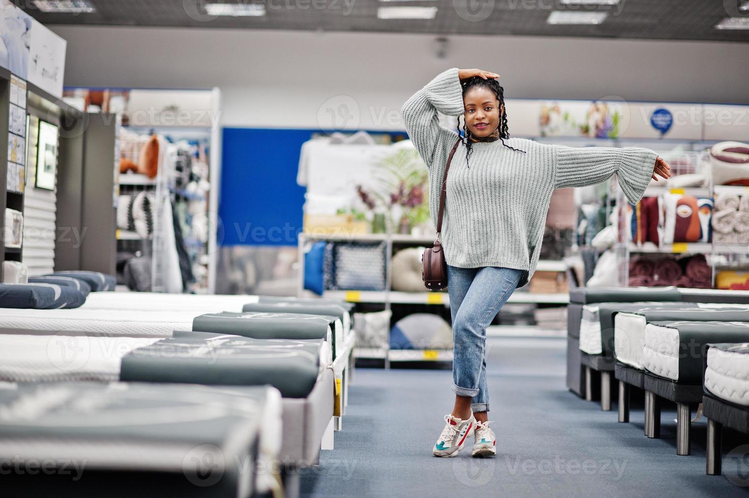 Mattress shop. African woman choosing the right furniture for her apartment in a modern home furnishings store. photo