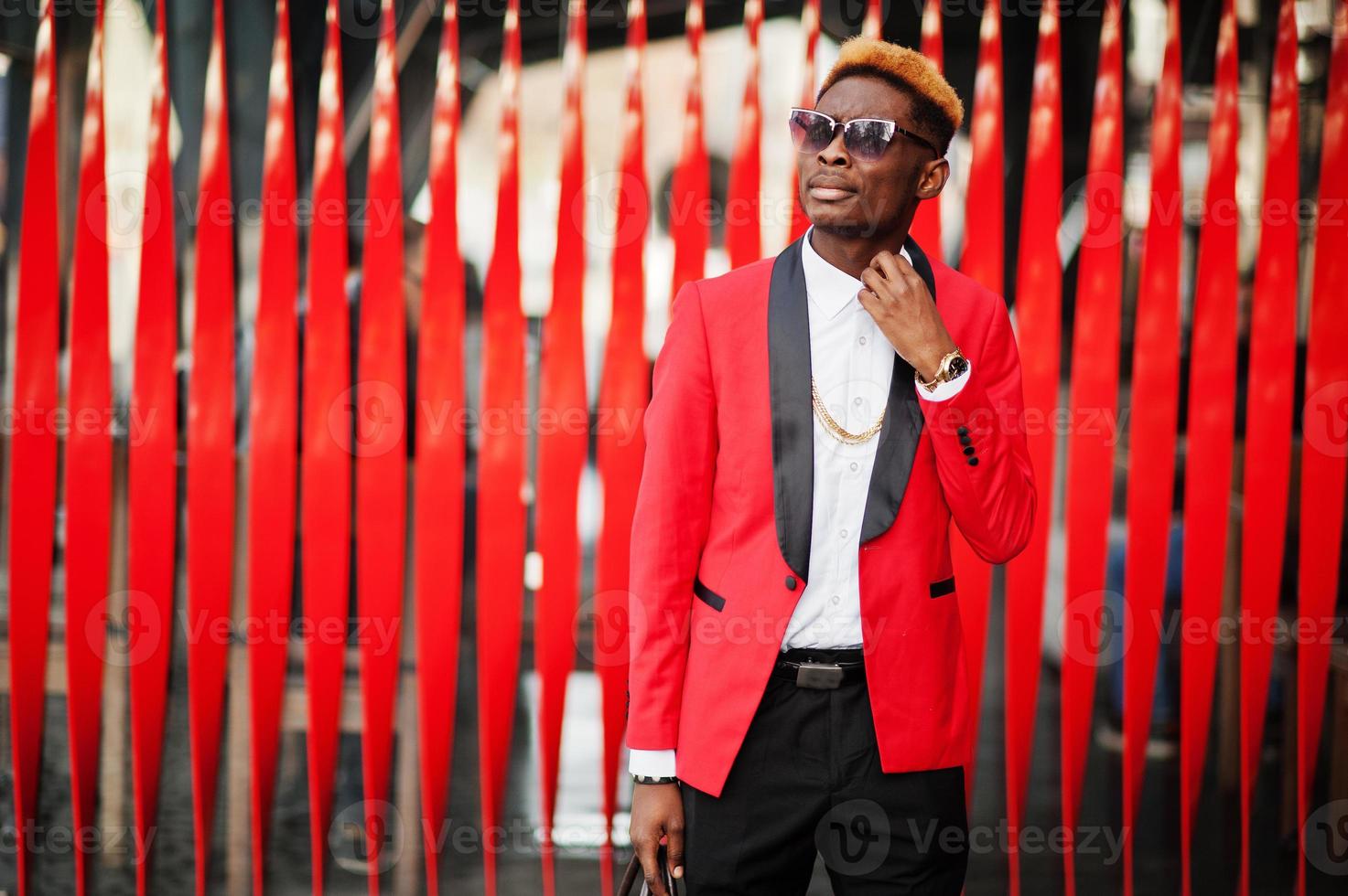 Fashion african american man model at red suit, with highlights hair posed at street. photo