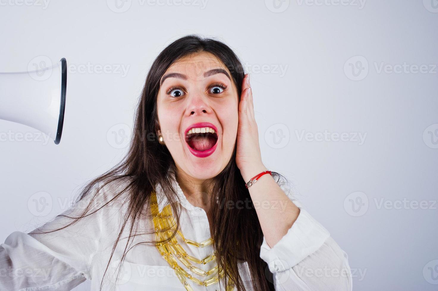 Close-up portrait of a woman covering her ears because of the megaphone. photo