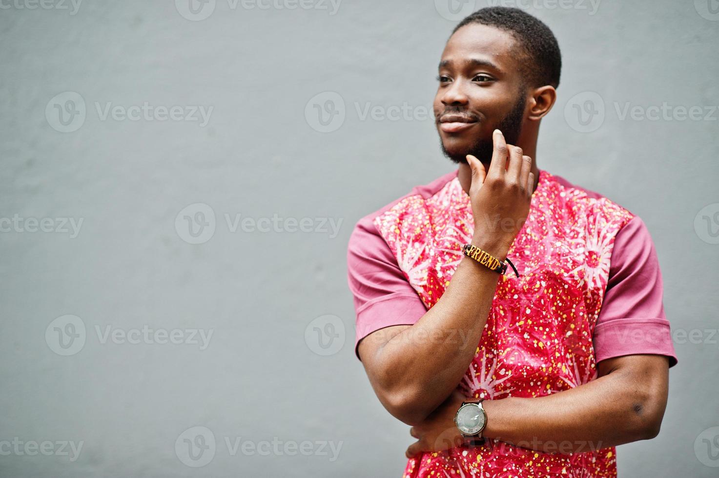 Portrait of a black young man wearing african traditional red colorful clothes. photo