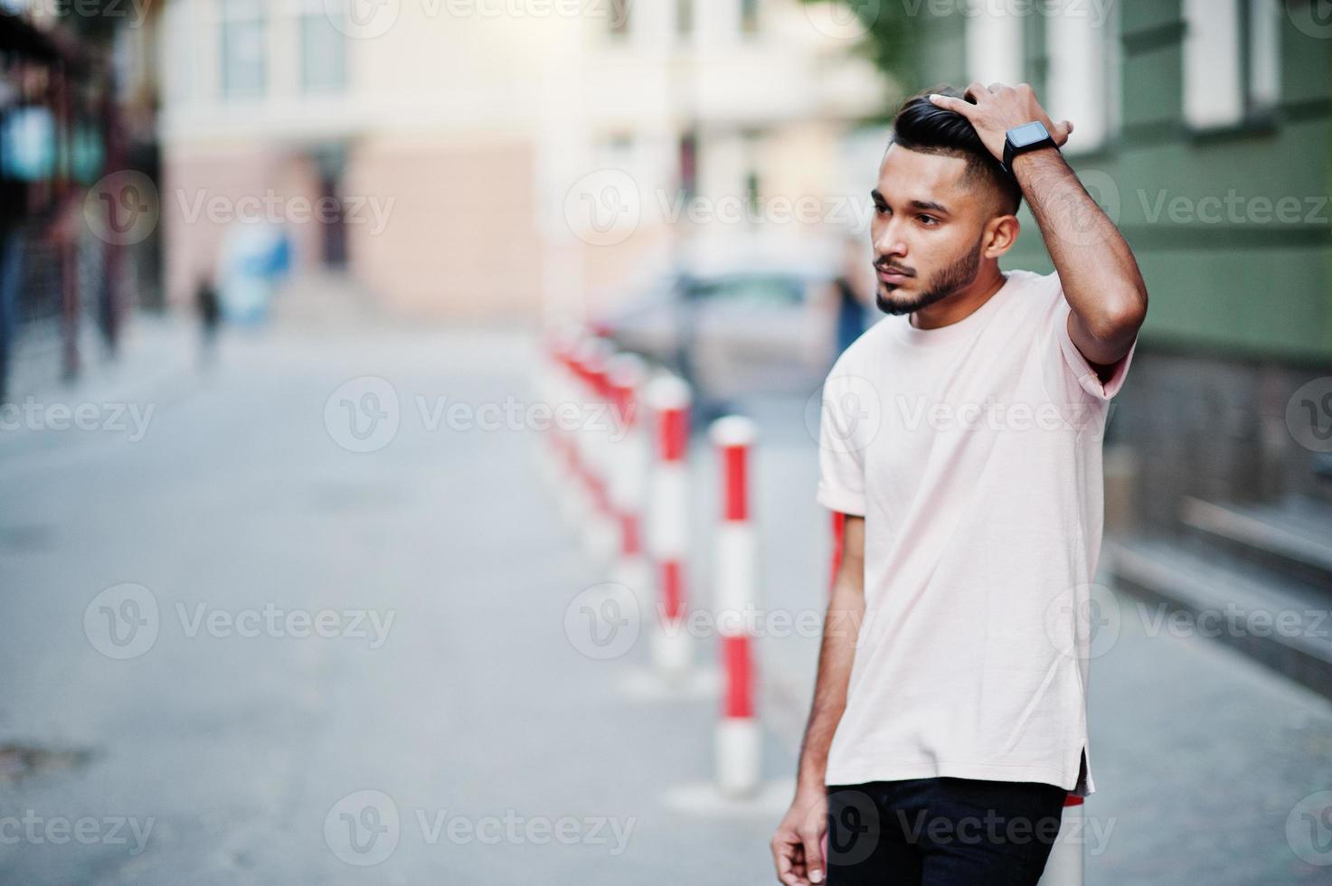 Stylish indian beard man at pink t-shirt. India model posed outdoor at streets of city. photo