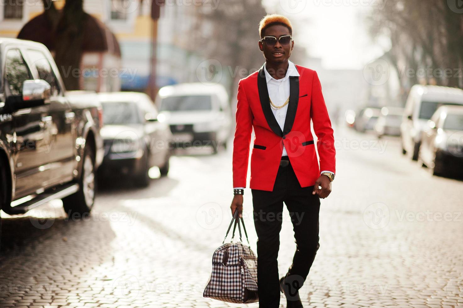 Fashion african american man model at red suit, with highlights hair and handbag posed at street. photo