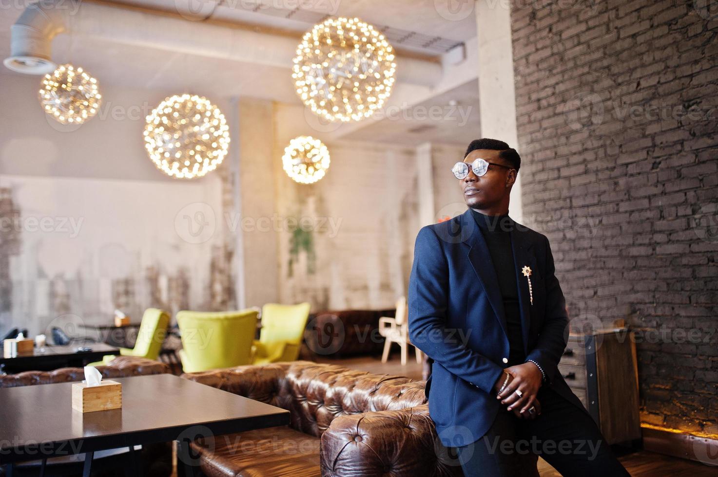 hombre afroamericano de moda en traje y gafas posó en el café. foto