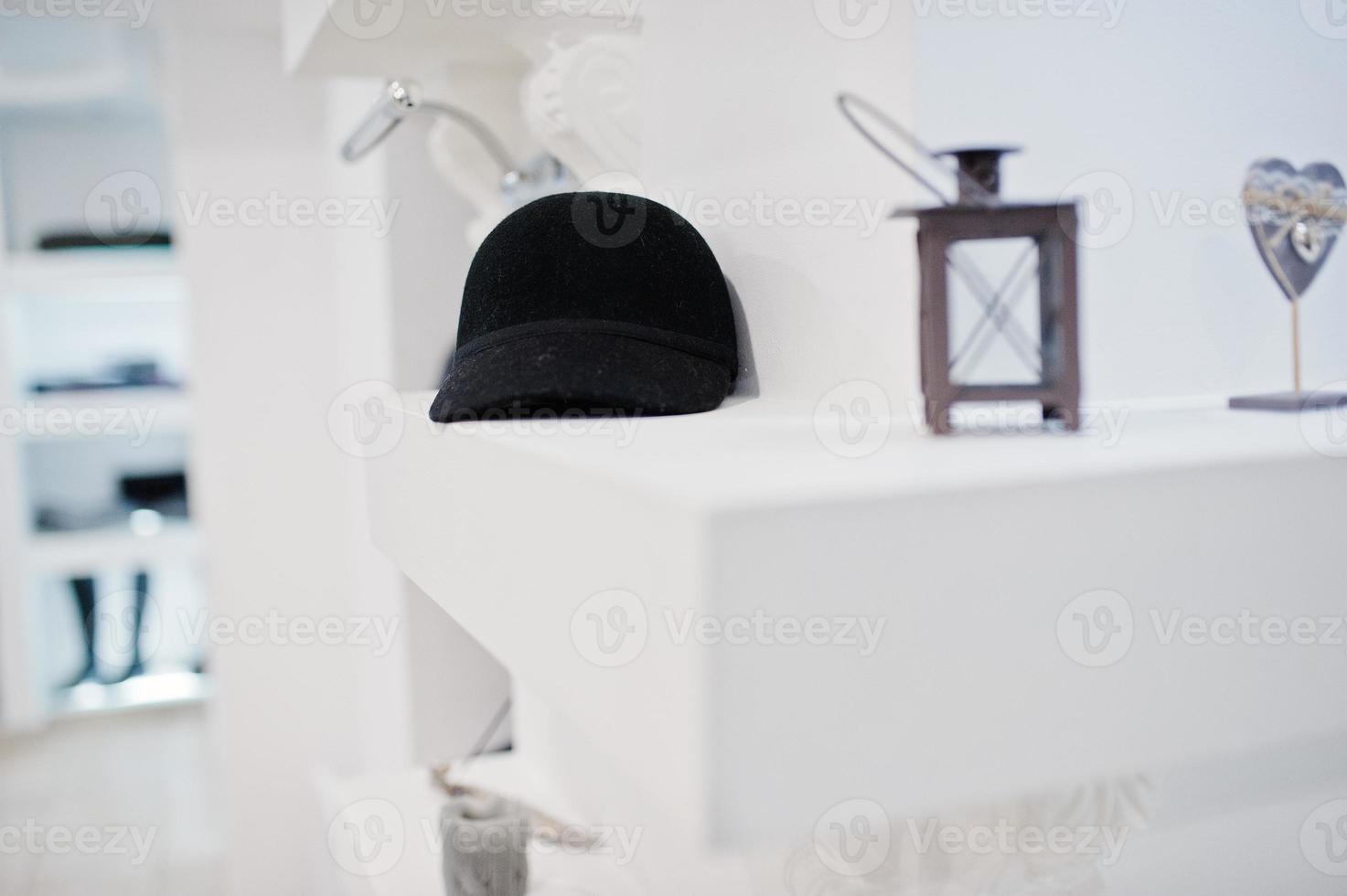 Close-up photo of a black cap on the shelf in the shop.