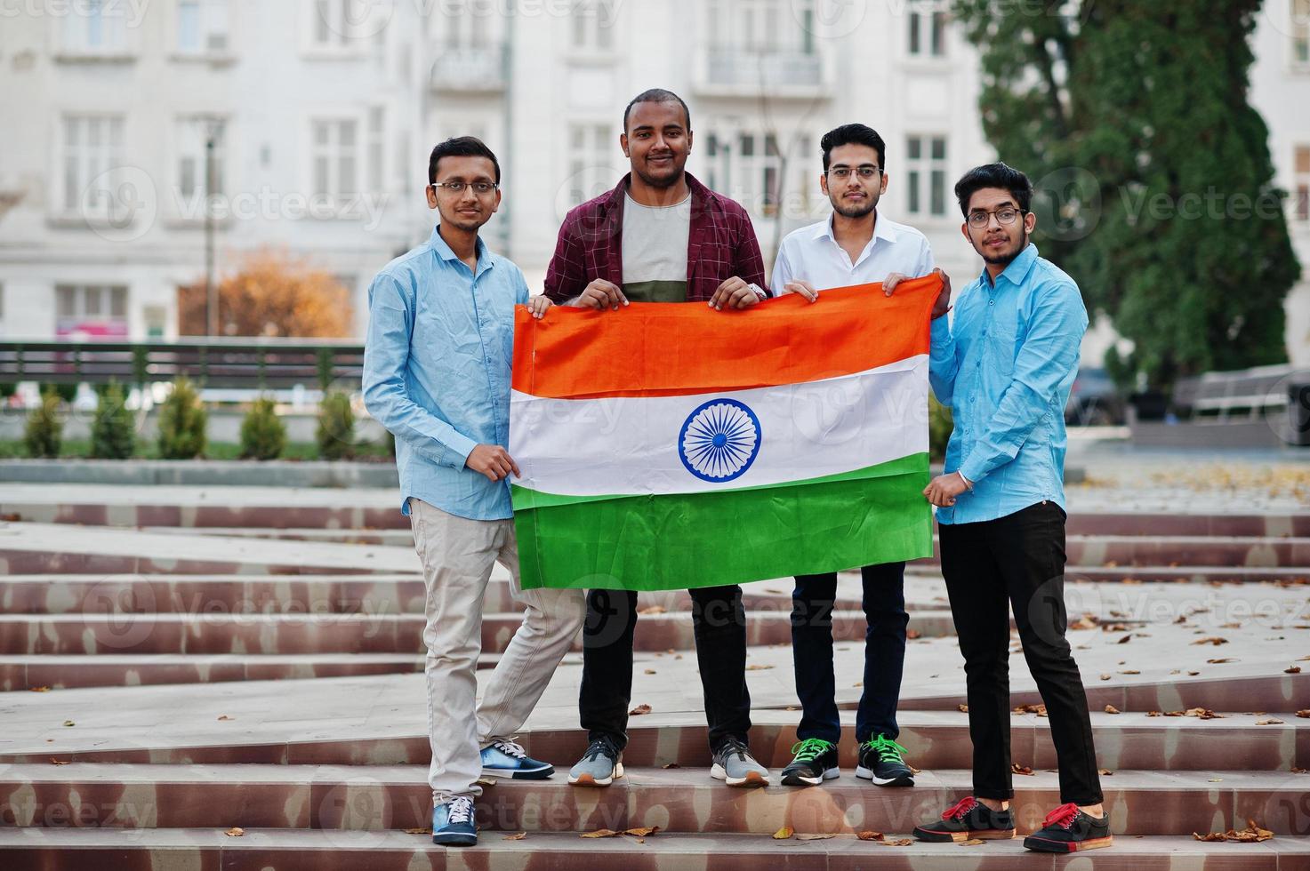 grupo de cuatro hombres indios del sur de asia con bandera india. foto