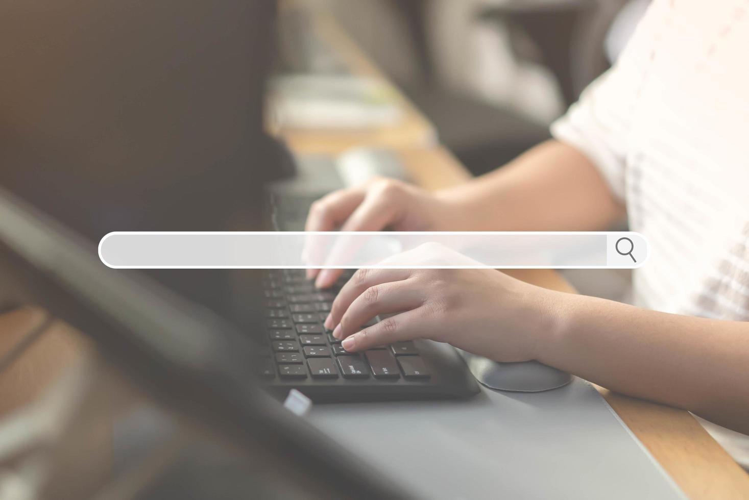 primer plano de la mano humana escribiendo en el teclado de la computadora como fondo del navegador del motor de búsqueda foto