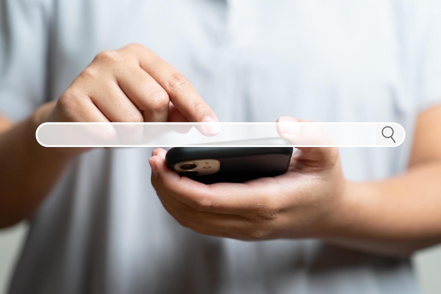 primer plano de la mano humana tocando el teléfono móvil como fondo del navegador del motor de búsqueda foto