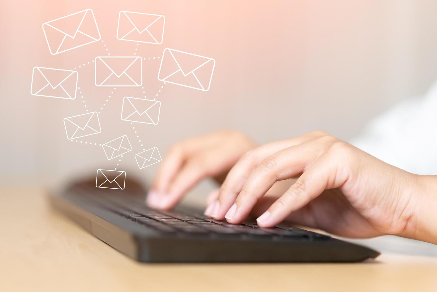 mano de mujer escribiendo en el concepto de teclado de recibir o enviar icono de correo electrónico en el escritorio de trabajo con computadora portátil foto