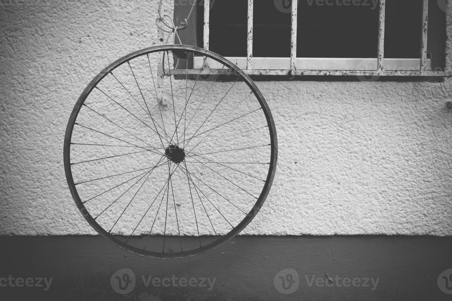 Bicycle wheel hanging outside the window photo