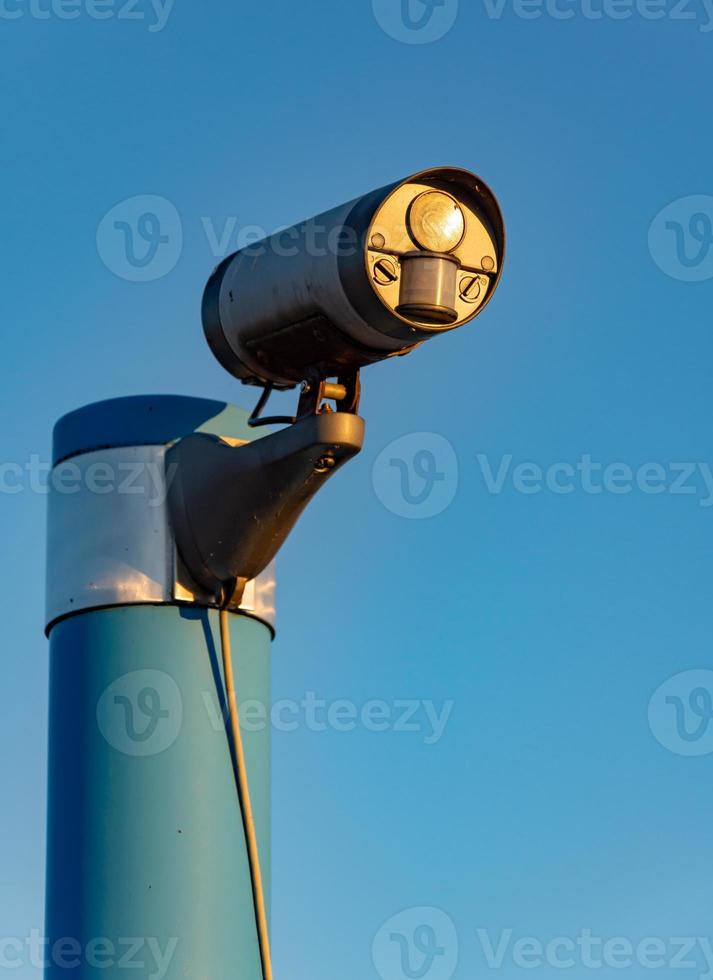 Security camera in front of blue sky photo
