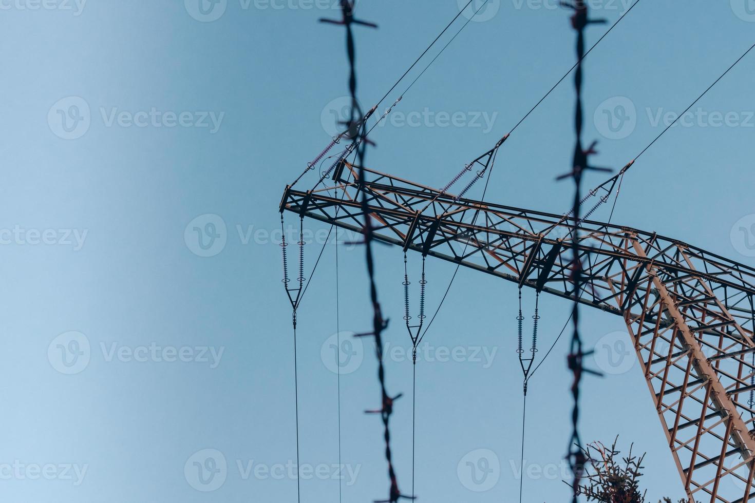High voltage electricity pole and barbed wire photo