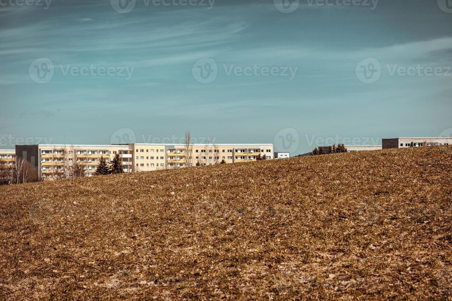 edificios vivos detrás de un campo en primavera foto