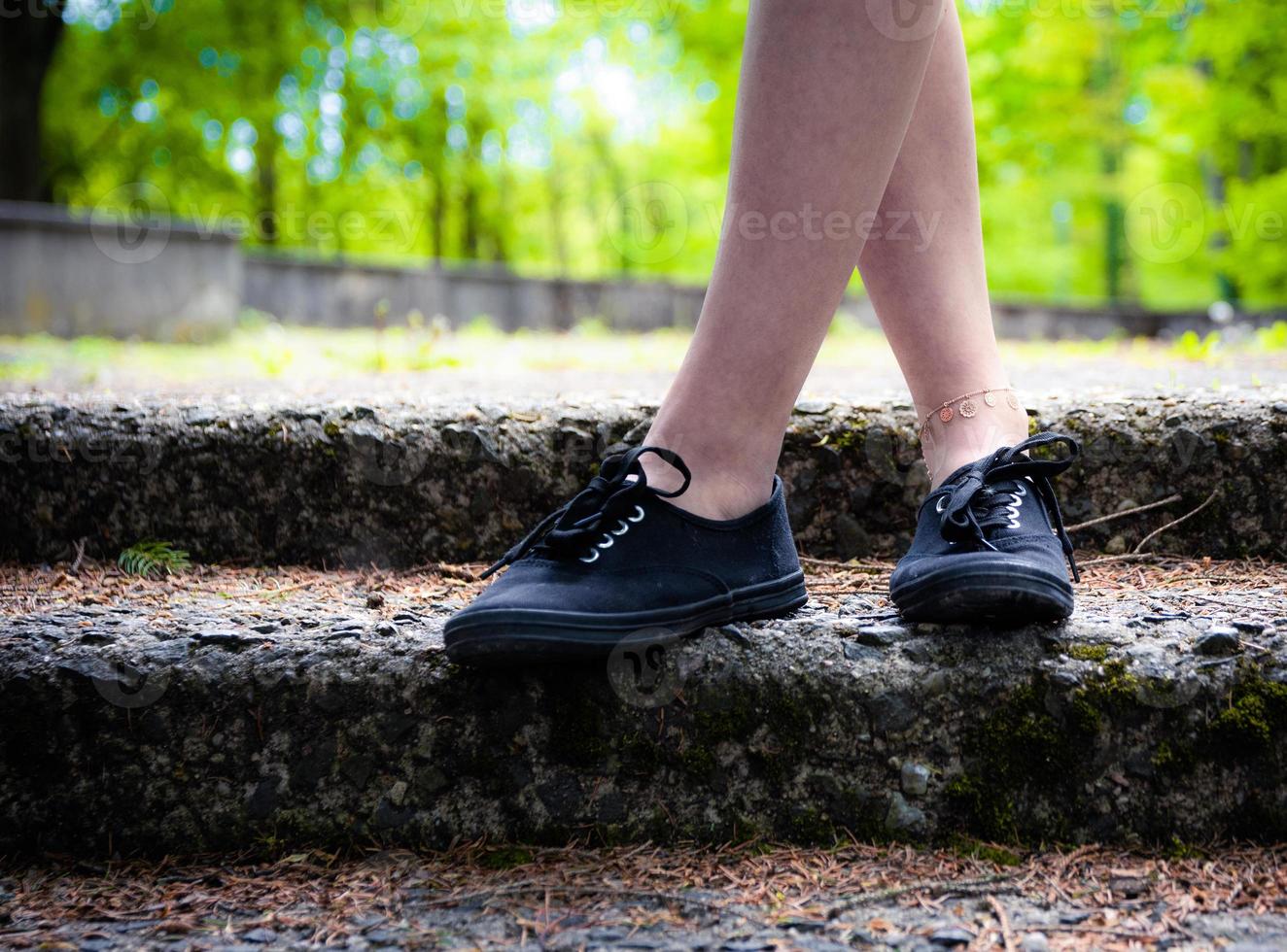 legs of a person standing in a public park photo