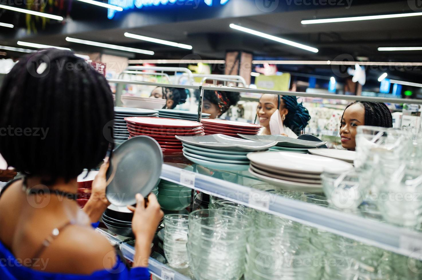 Group of african womans look color plates on supermarket shelves. photo