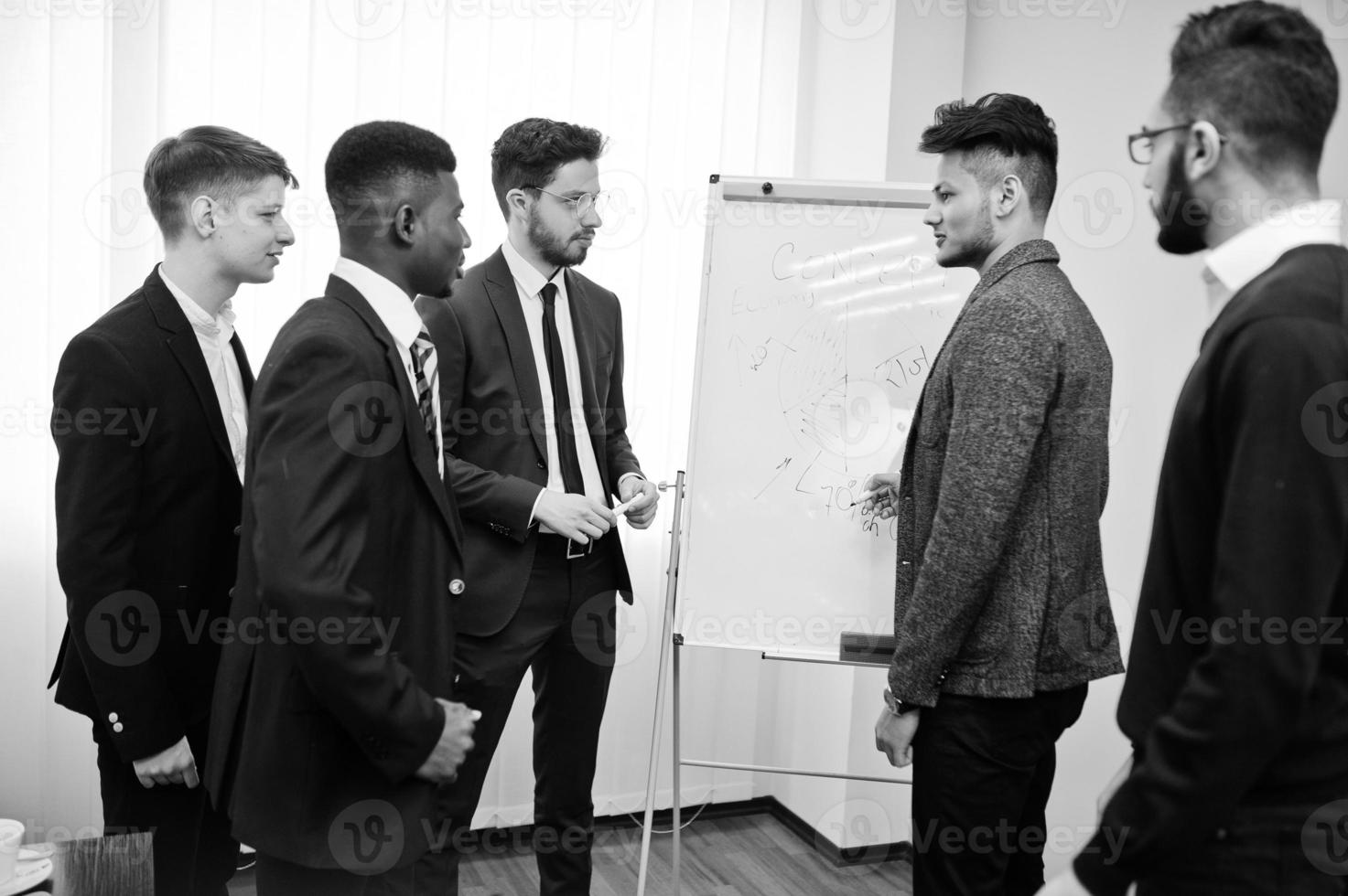 Male colleagues working in team cooperate , multiracial crew of employees concentrated on project planning against flipchart and discussing ideas. photo