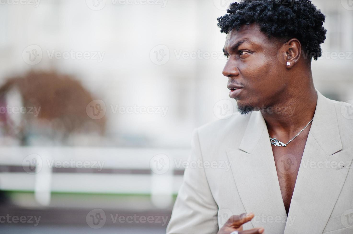 Stylish afro man in beige old school suit. Fashionable young African male in casual jacket on bare torso. photo