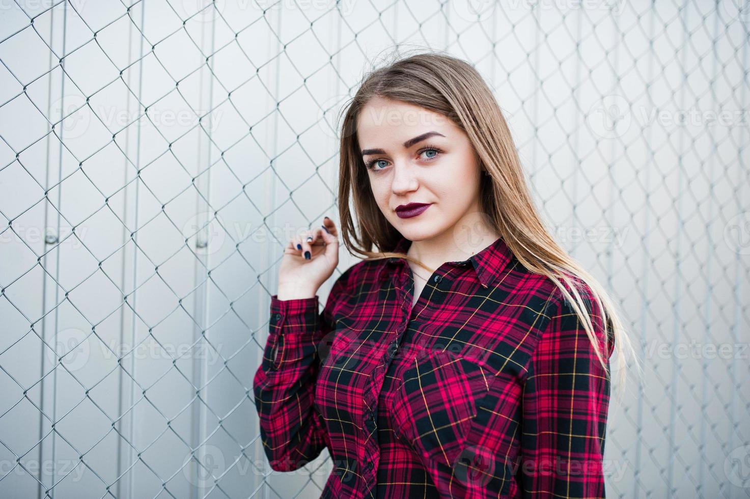 Young hipster girl in checkered shirt posed outdoor. photo