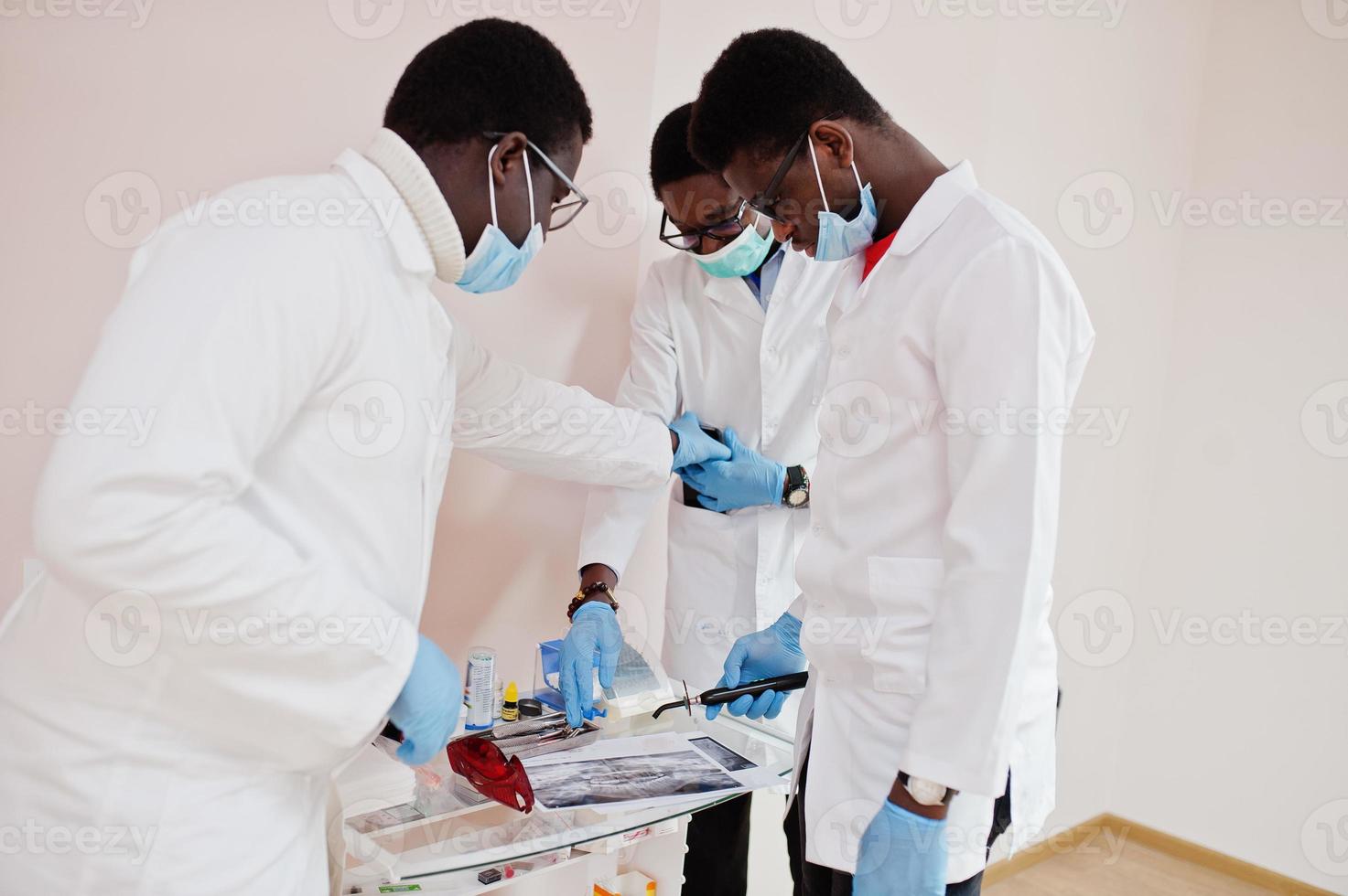 Three african american male doctors colleagues in clinic. photo