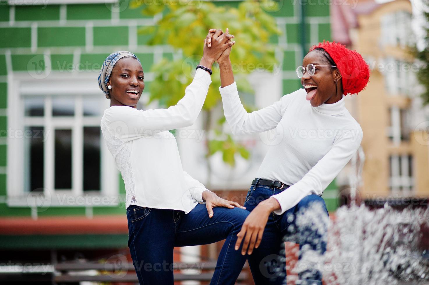 Two young modern fashionable, attractive, tall and slim african muslim womans in hijab or turban head scarf posed together. photo