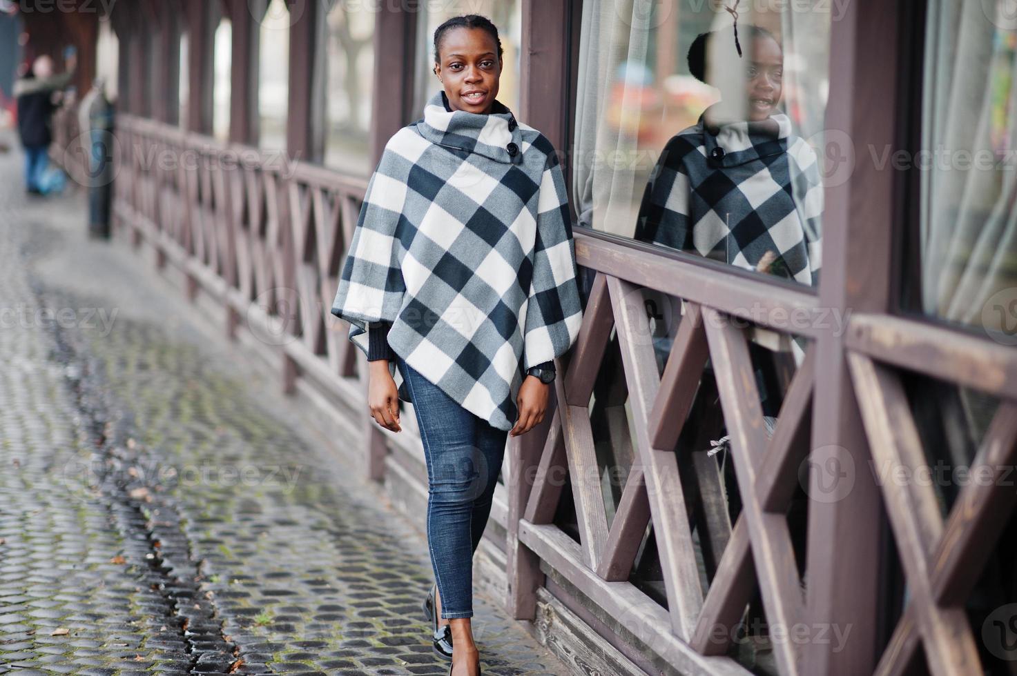 African woman in checkered cape posed outdoor. photo