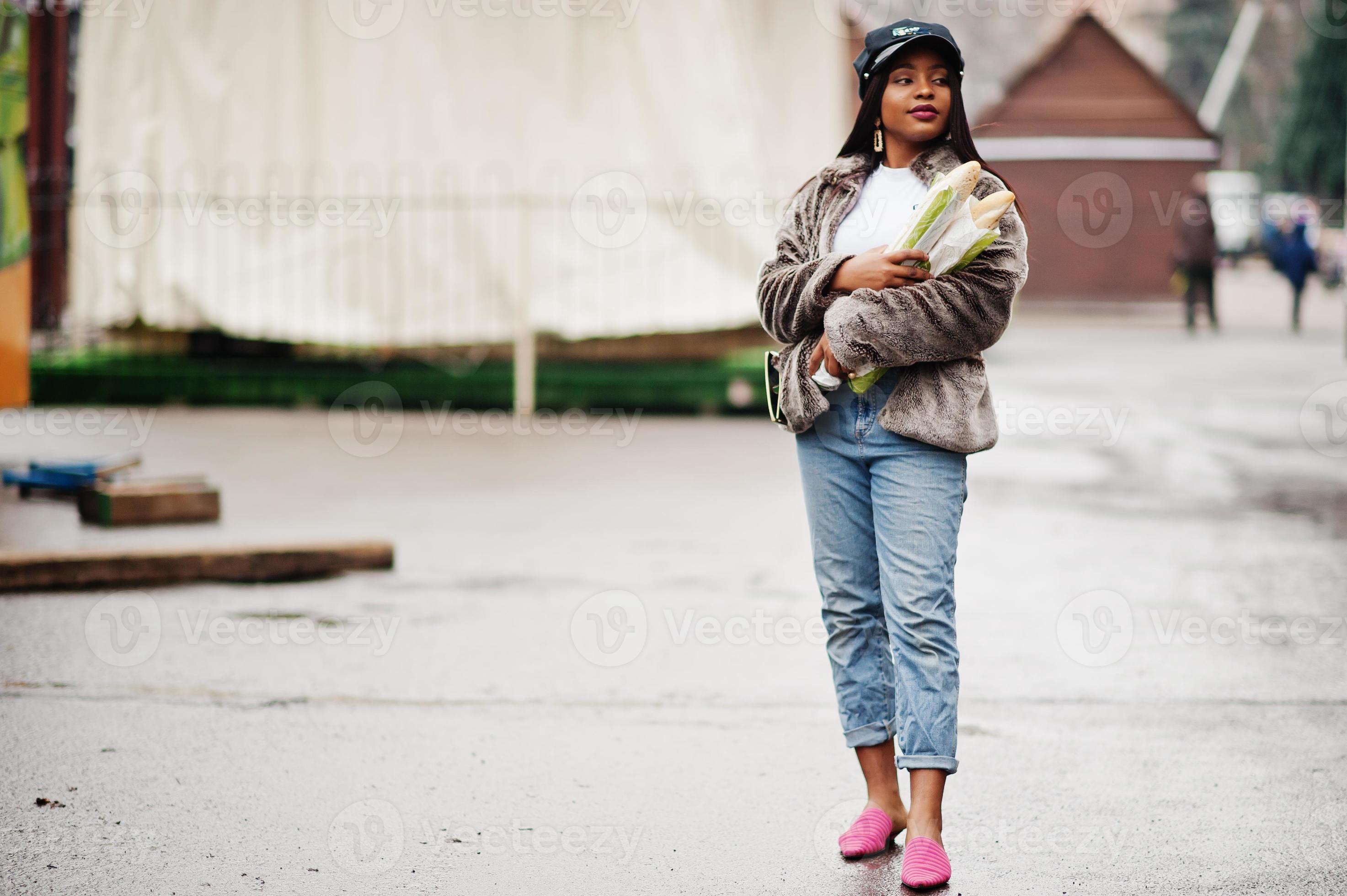mujer afroamericana de moda con gorra negra y piel con dos rollos de  baguette en las manos. 10430062 Foto de stock en Vecteezy