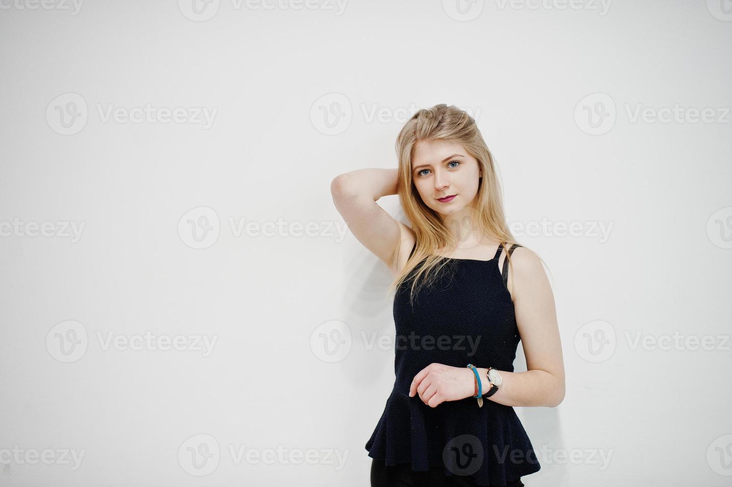 Portrait of blonde girl in black wear against white background. photo