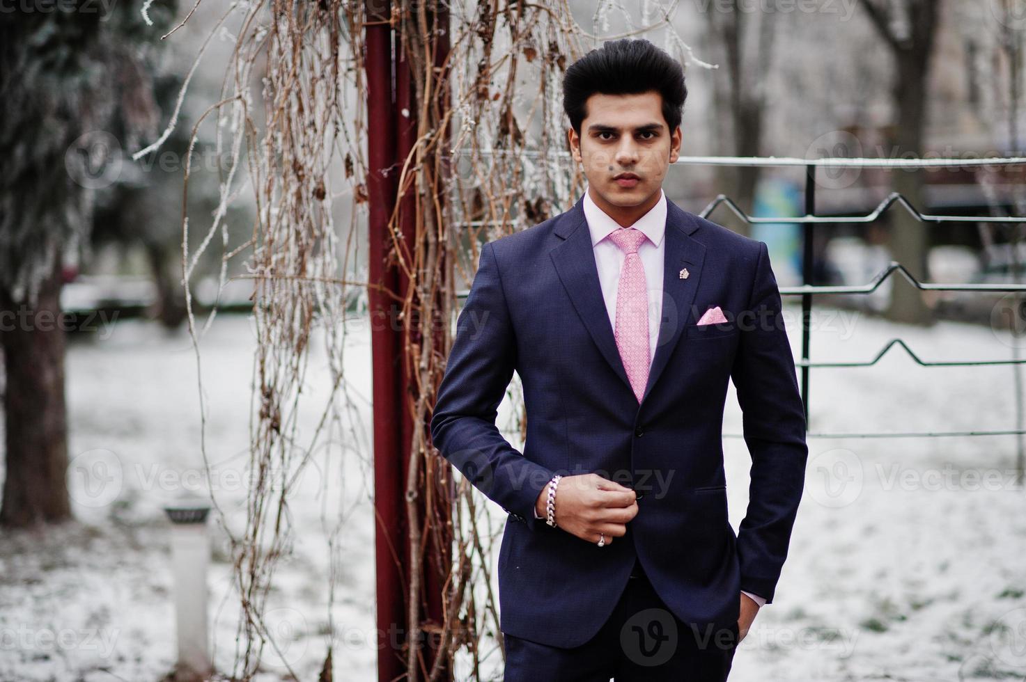 Elegant indian macho man model on suit and pink tie posed on winter day. photo