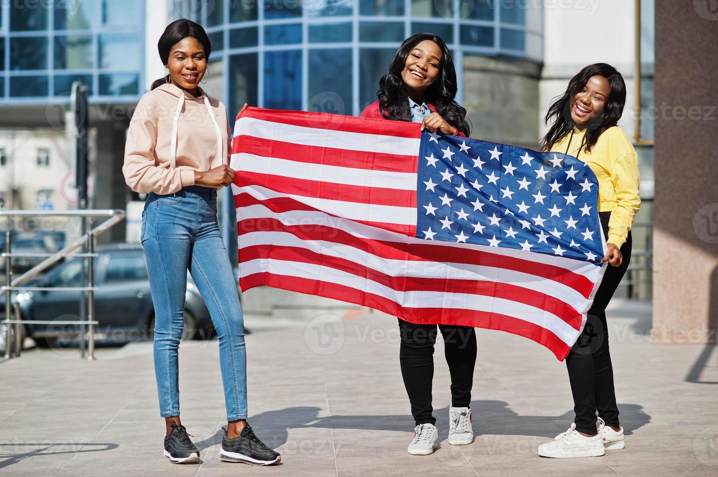 Three young college african american womans friends with flag of USA. photo