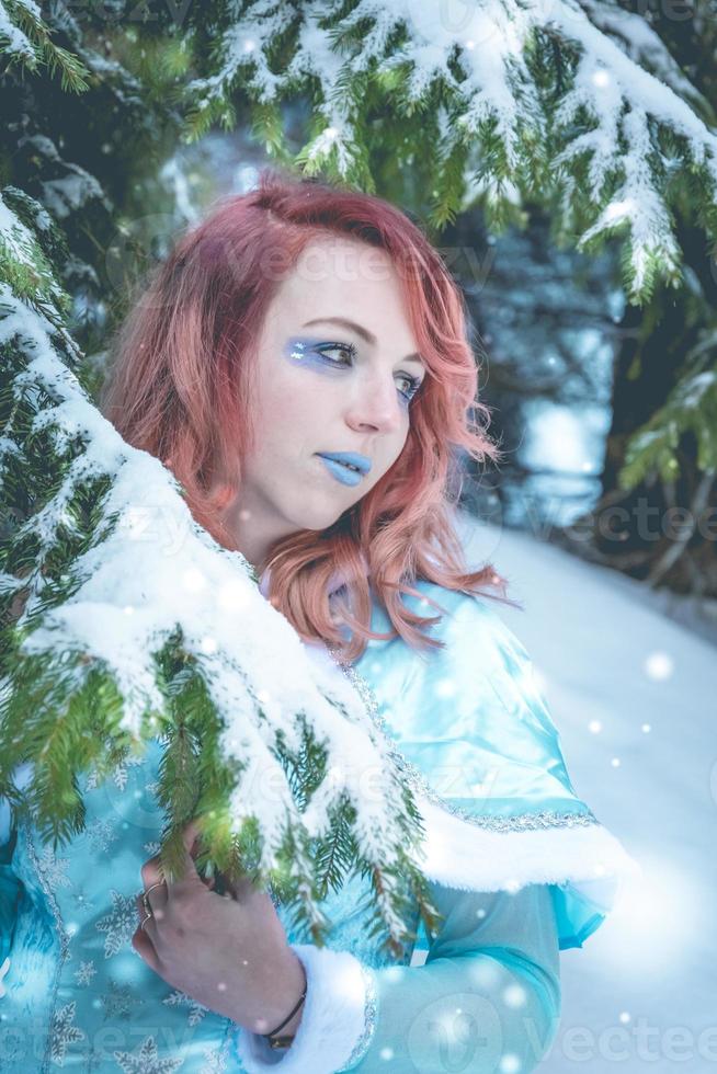 Attractive red haired woman in winter cape photo