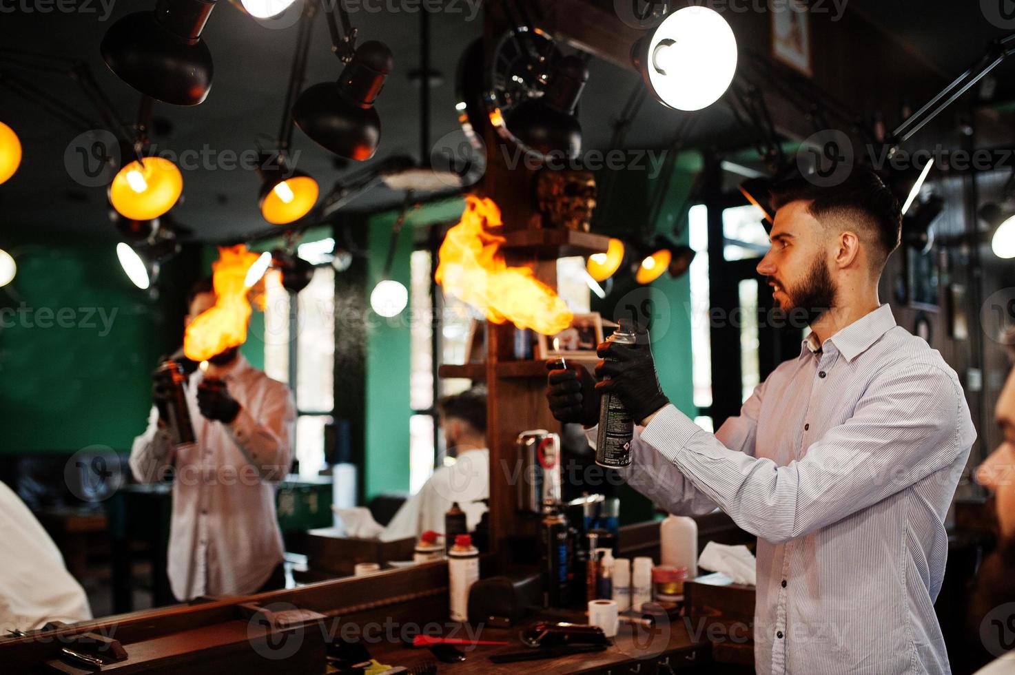 Handsome bearded man at the barbershop, barber at work with fire show. photo