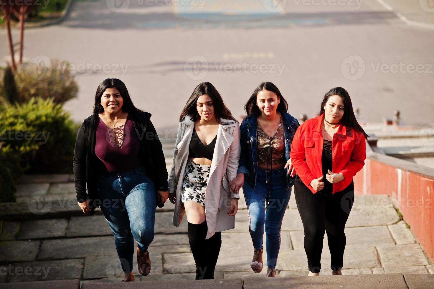 Group of four happy and pretty latino girls from Ecuador posed at street. photo