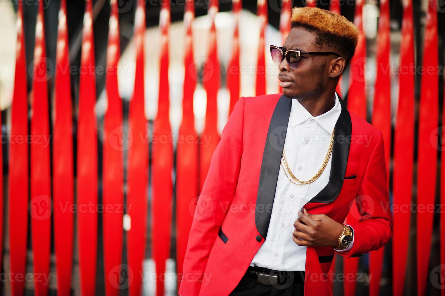Fashion african american man model at red suit, with highlights hair posed at street. photo