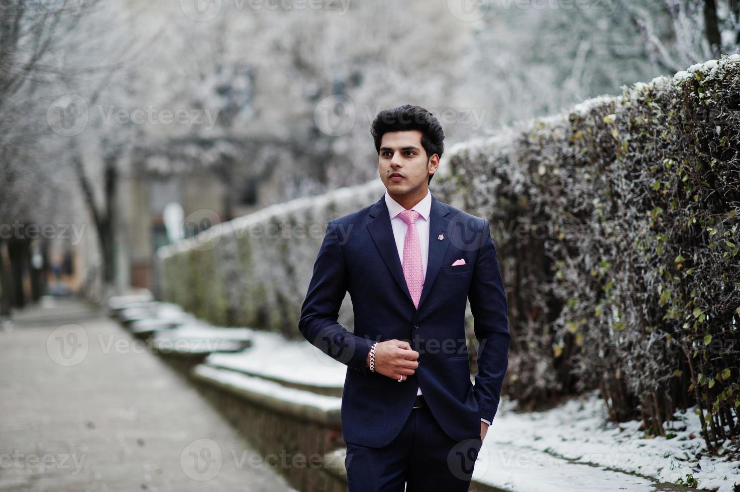 modelo de hombre indio con traje y corbata rosa posado en el de invierno. 10482290 Foto de stock en Vecteezy