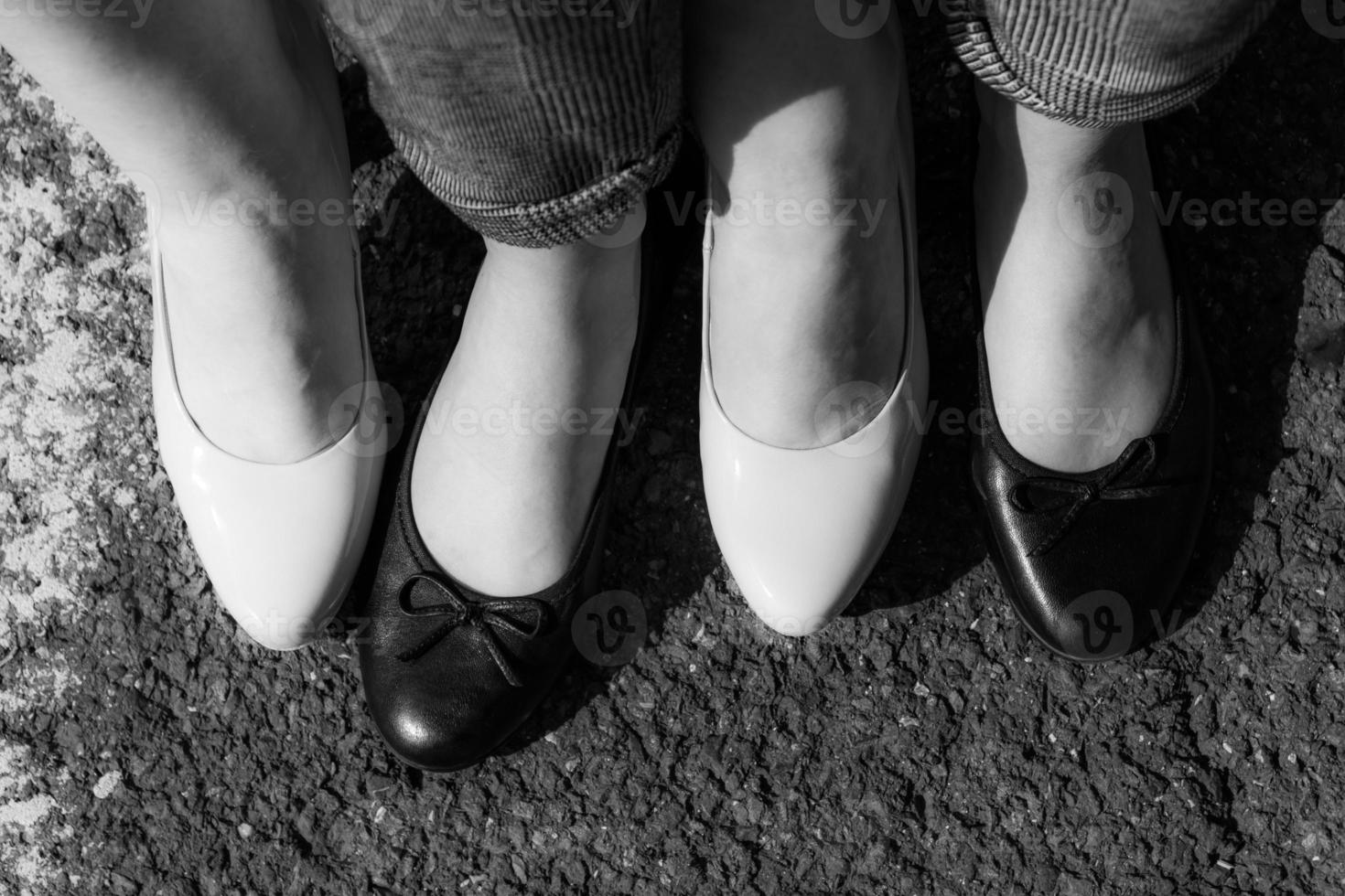 Two woman wearing black and white court shoes photo