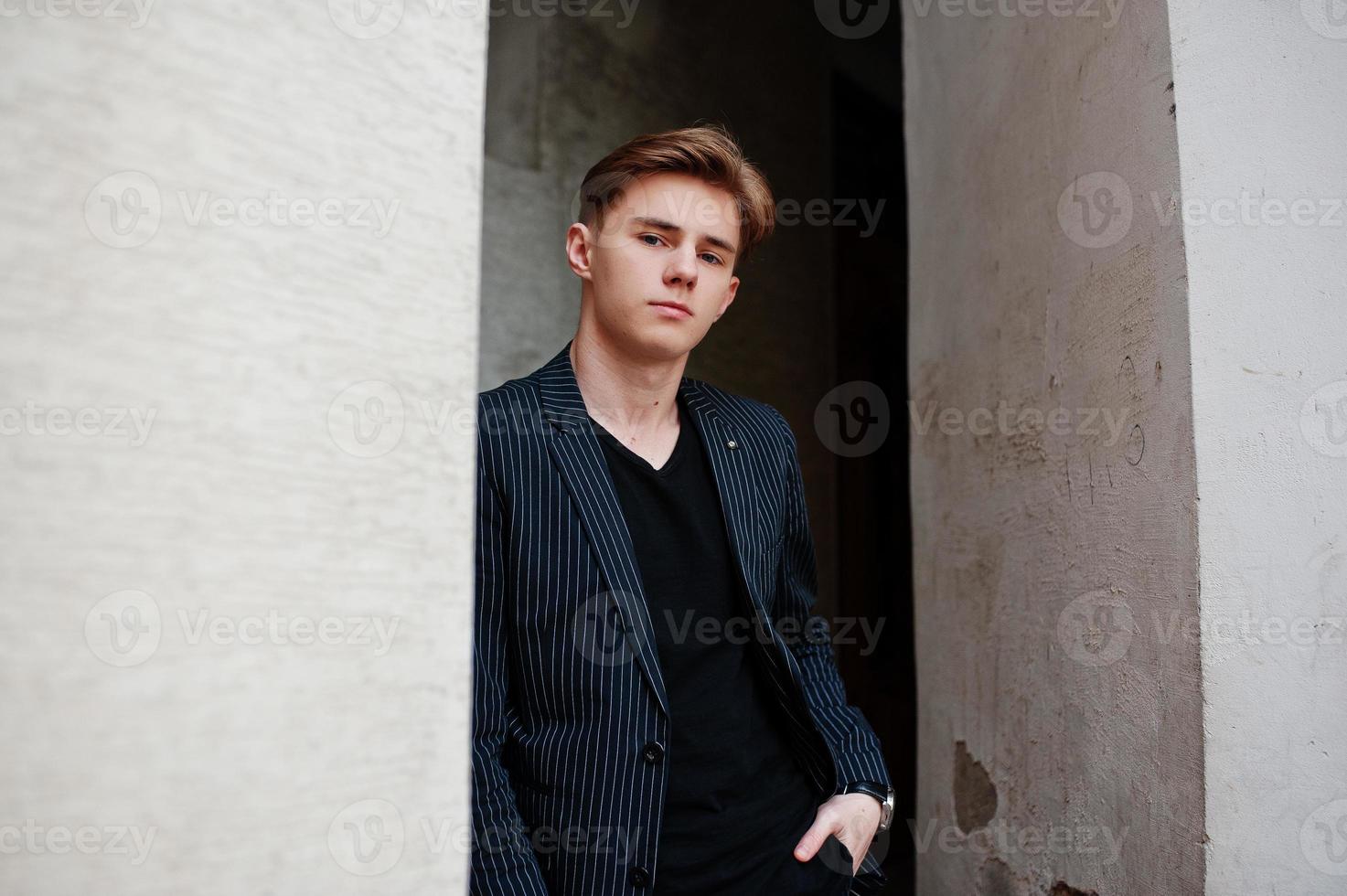 joven macho con estilo en chaqueta negra planteada al aire libre de la calle. increíble modelo de hombre. foto