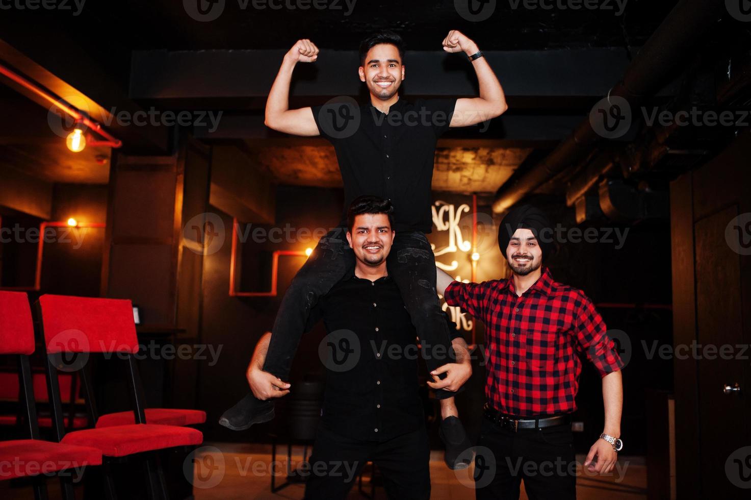 Group of indian man friends having fun and rest at night club. photo