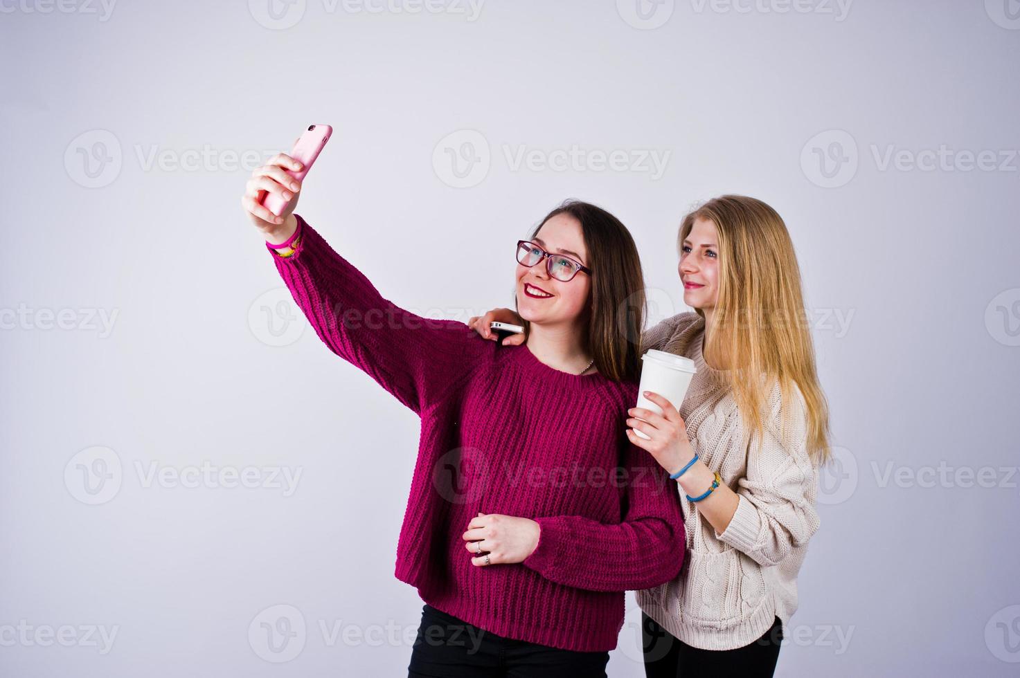 Two girls in purple dresses taking selfie in the studio. photo