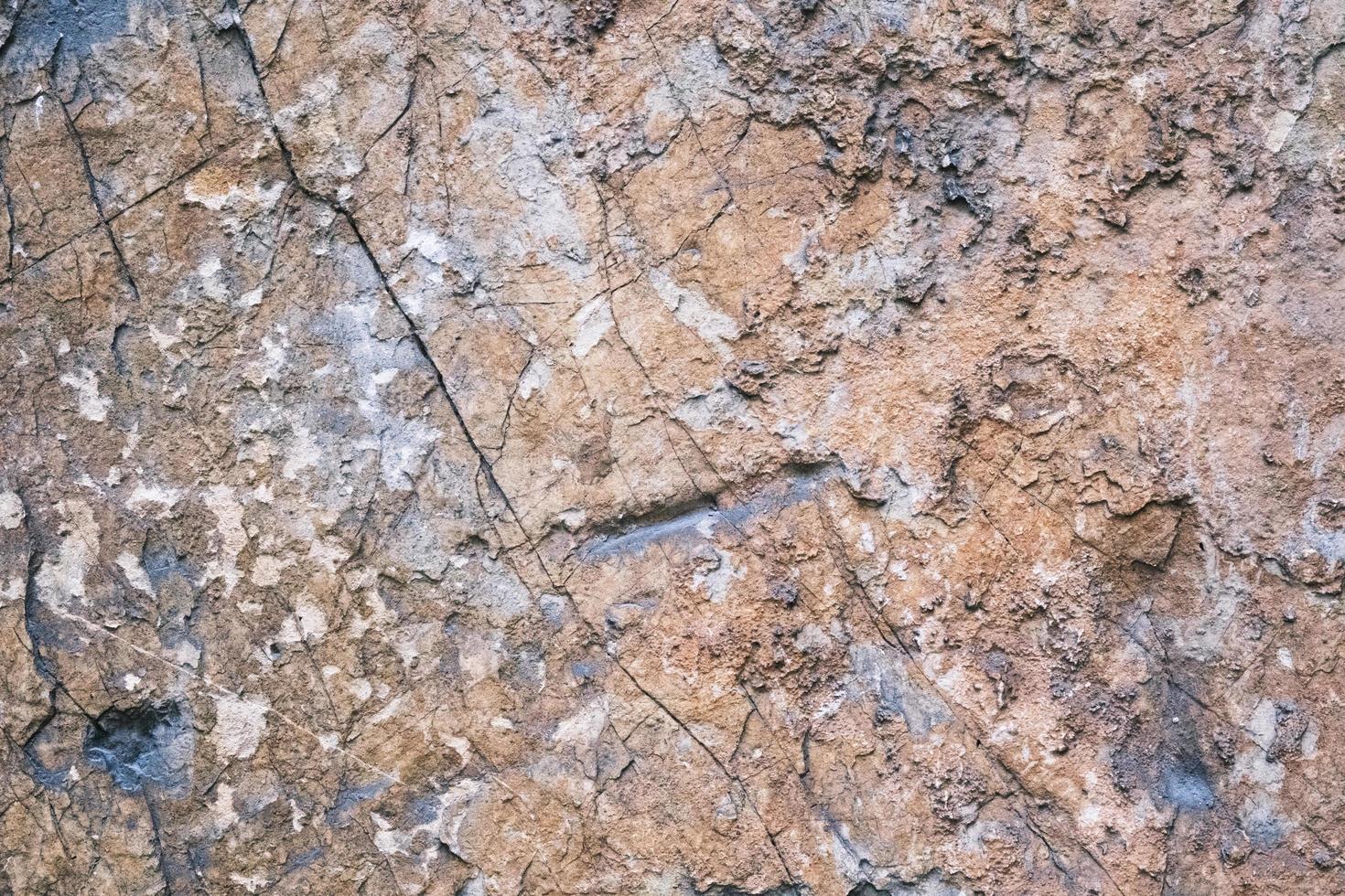 old weathered rock wall with beautiful cracks, pattern and texture, colorful background, textured surface photo