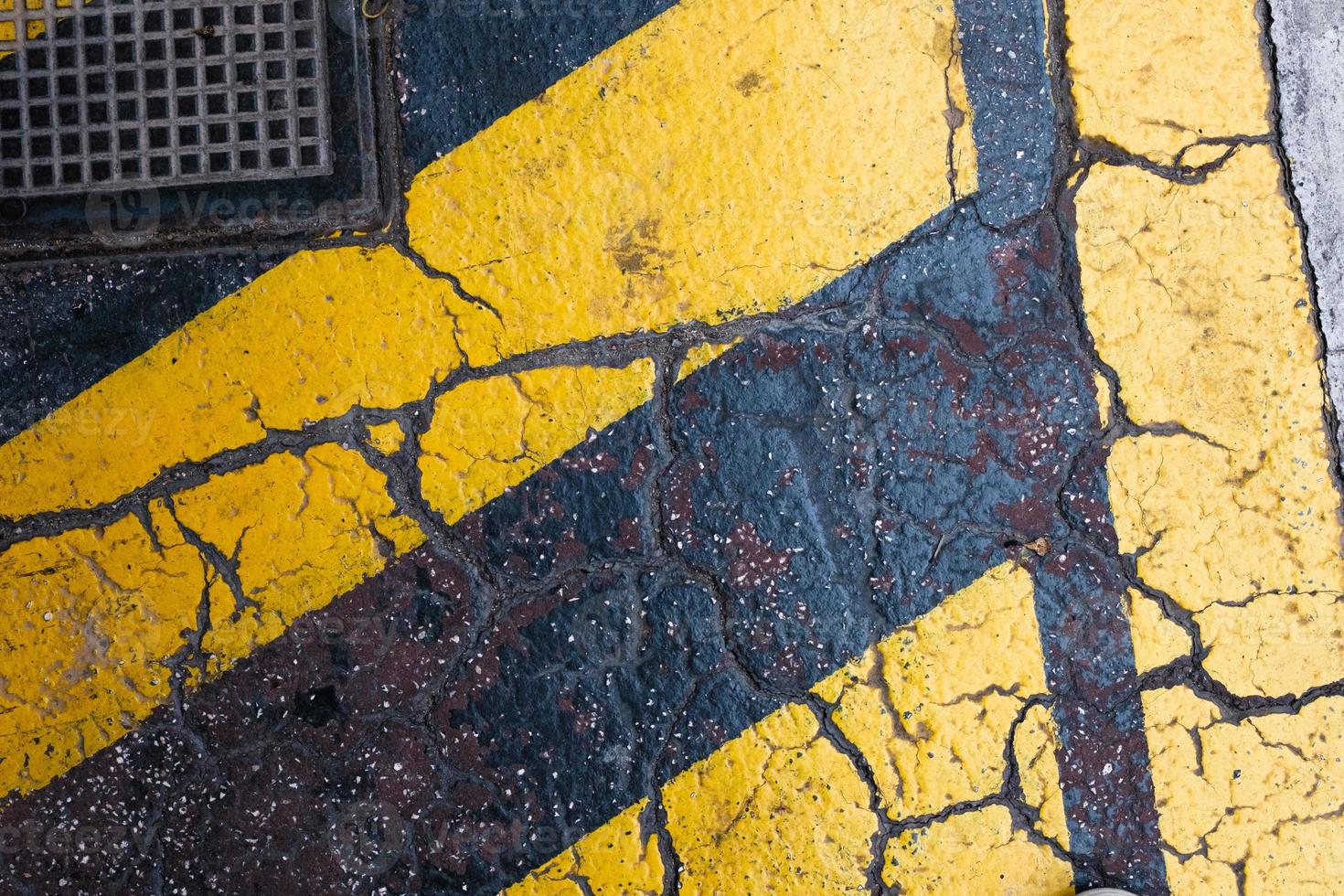 Yellow stripes on the grungy cracked asphalt, pattern and texture, colorful background, textured surface photo